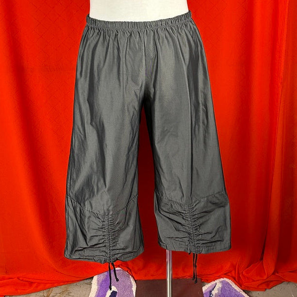 Gray pants on a mannequin against an orange curtain